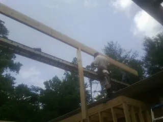 Carpenter setting a ridge beam over a new addition frame — Ice Dam Removal by Roofing Brothers in Rock Port