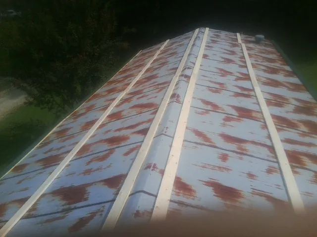 Rusted metal roof panels with new wood purlins before replacement — Storm Damage Roof Repair in Rock Port by Roofing Brothers