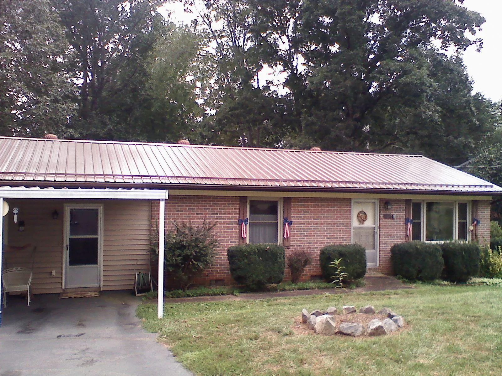 Bronze metal roof and carport on a brick ranch home — Roof Repair work by our crew in Rock Port